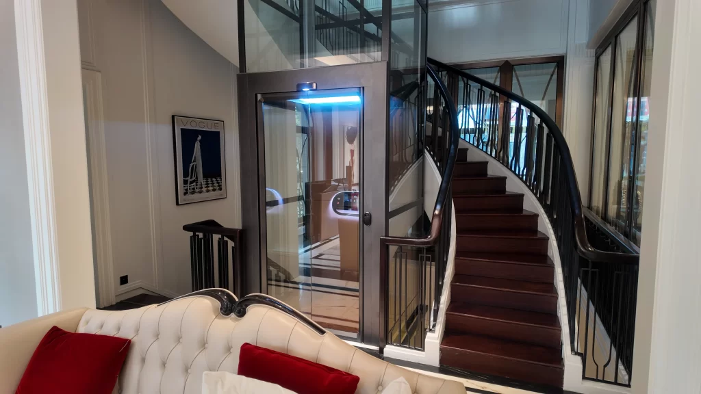 Lift rumah kaca Kalea di area tangga rumah mewah dengan desain klasik