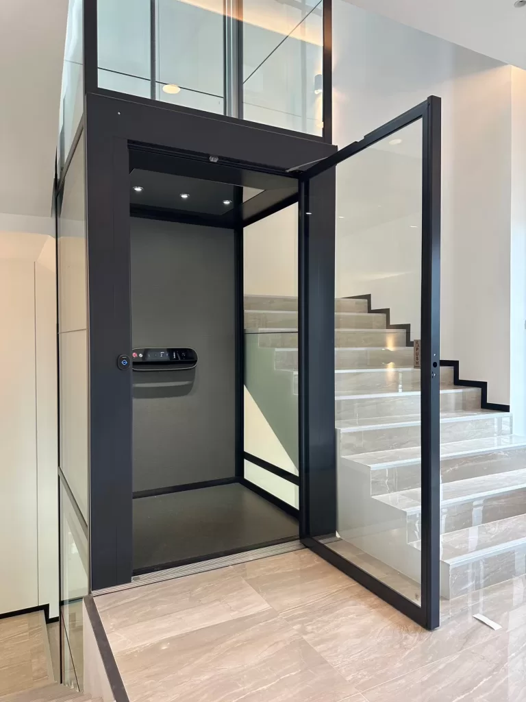 Lift rumah mewah Kalea X80 dengan shaft warna hitam di tengah tangga